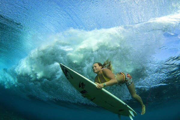 Surfer mit einem Brett unter Wasser