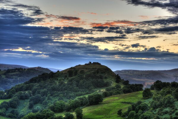 Hügel, die bei Sonnenuntergang mit Wald bewachsen sind