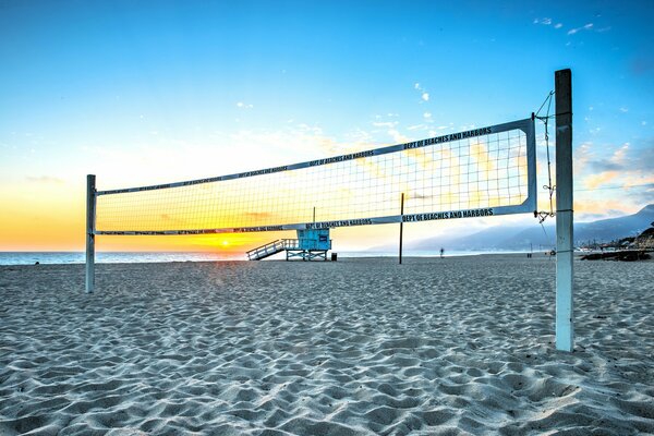 Beach-volley au coucher du soleil d été