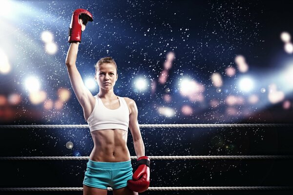 A girl in boxing gloves in the ring
