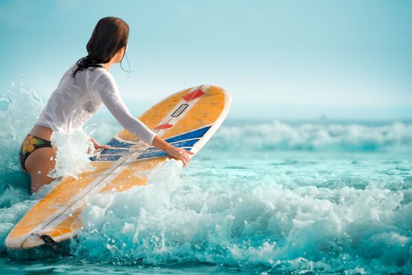 Chica en las olas en una tabla de surf