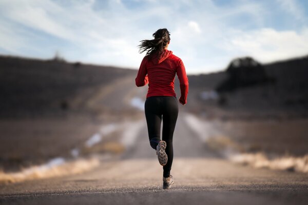 Ragazza sportiva che corre lungo la strada