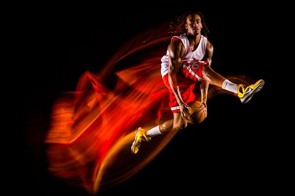 Ein Basketballsportler in einer Flugbahn mit einem Ball