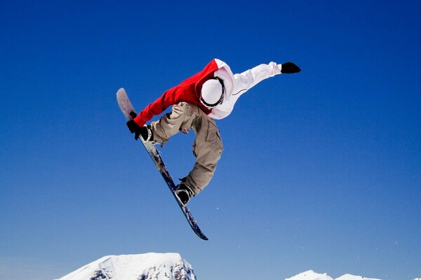 The trick of a snowboarder with a brilliant jump