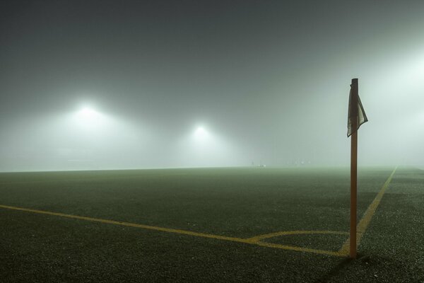 Ein Fußballplatz und ein Häkchen im Nebel