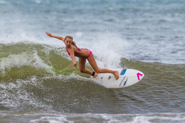 Chica en el surf en el mar en la ola