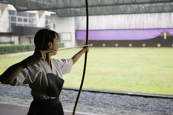 A girl with a bow shoots at a target