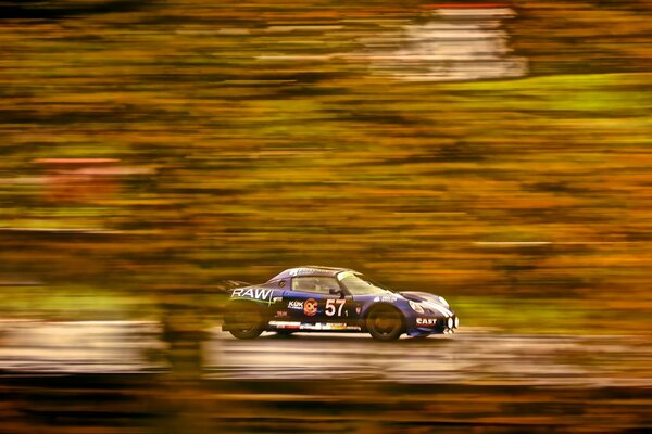 The car rushes along the track in a race