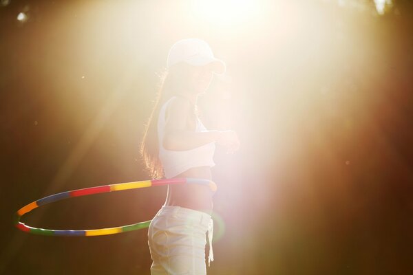 A girl turns a hula hoop in nature