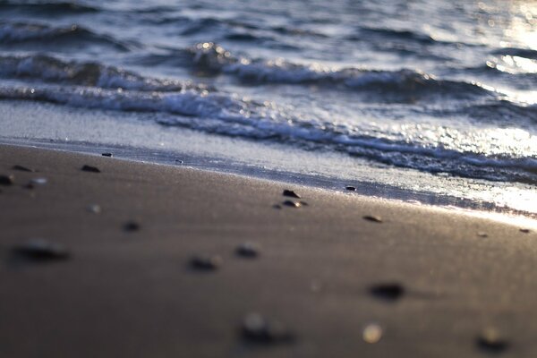 Sandstrand und Meer mit Sonnenstrahlen