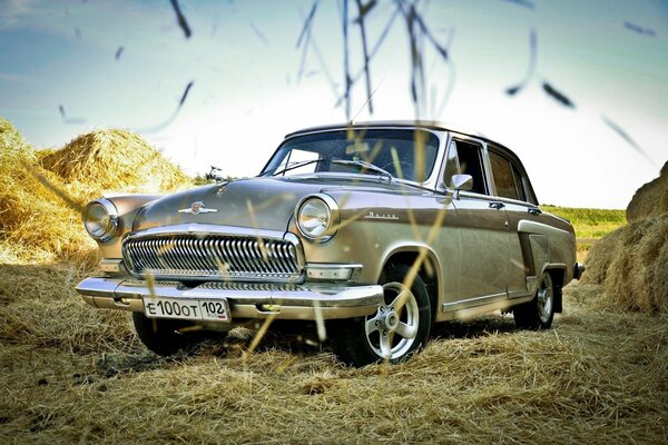 A car in a field with haystacks