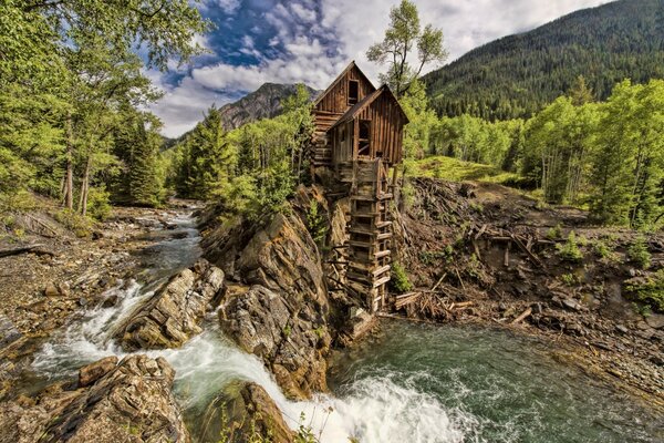 Haus in der Nähe eines kleinen Wasserfalls und eines Flusses