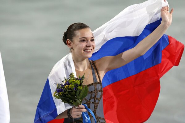 Sotnikova wrapped in our flag on the ice rink with a bouquet
