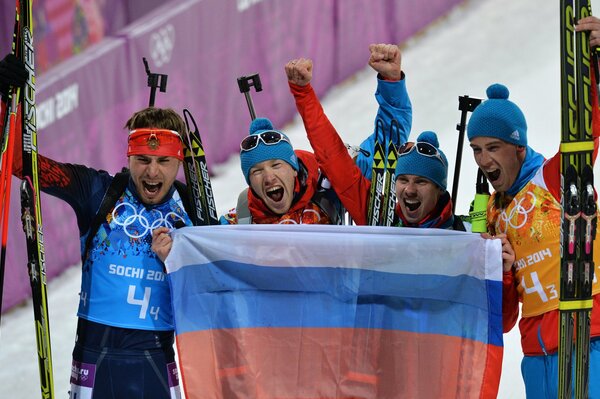 Participants of the biathlon relay Anton Shipulin, Alexey Volkov, Dmitry Malyshko and Evgeny Ustyugov holding the Russian flag at the Sochi 2014 Olympics