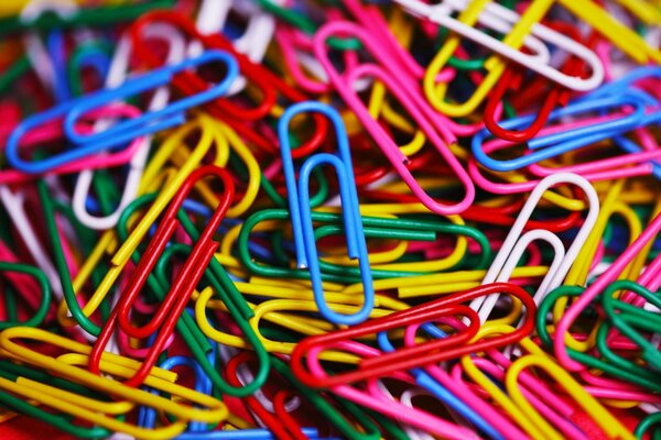 A lot of scattered colored paper clips