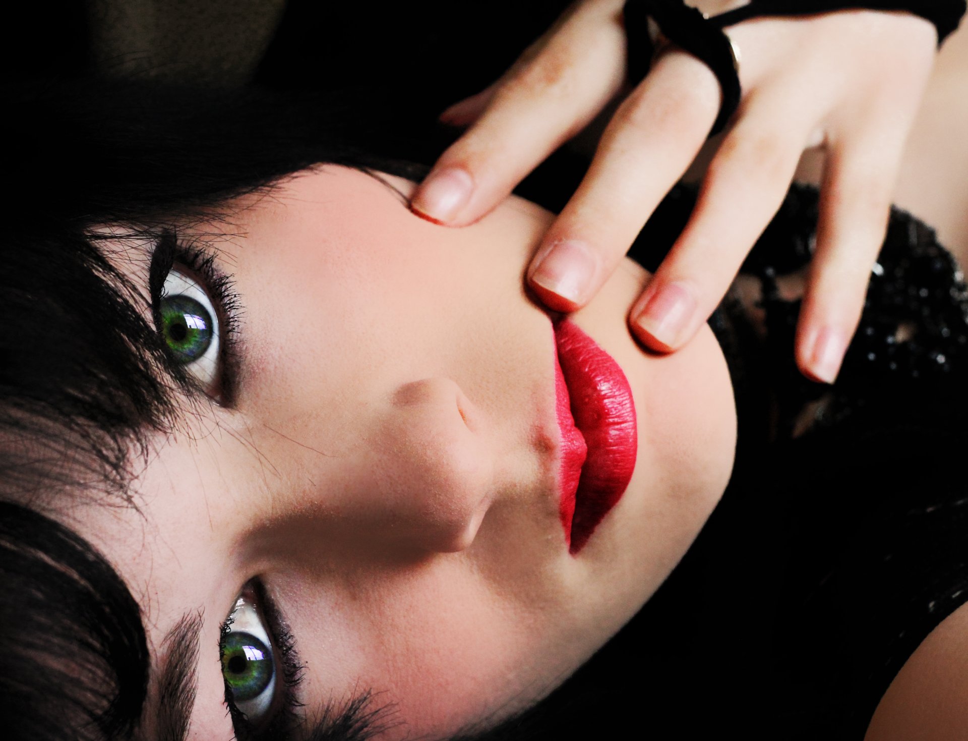 chica ojos verdes maquillaje labios rojos cabello negro mano