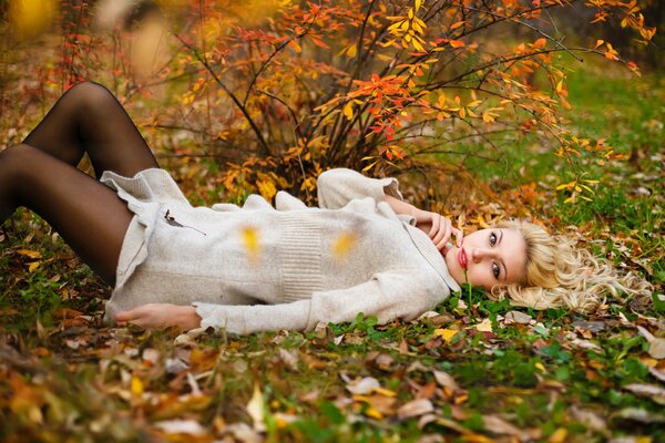 The girl lies on the autumn foliage