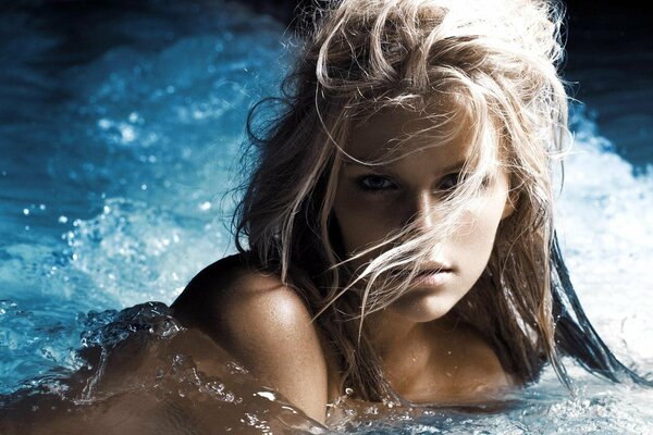 Blonde with long hair swims in the pool