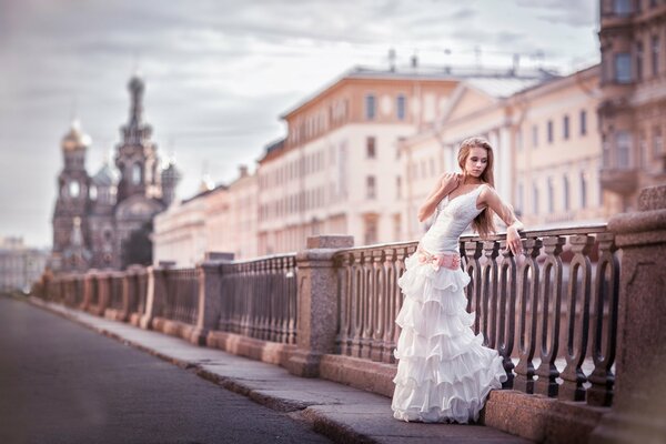 Una chica con un vestido de novia en el fondo de la calle en San Petersburgo