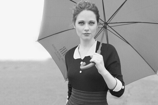 Against the background of nature, a girl with an umbrella