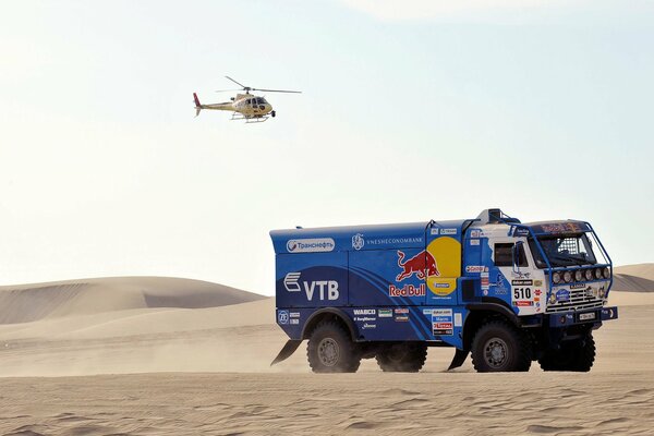 Camion da corsa nel deserto con elicottero