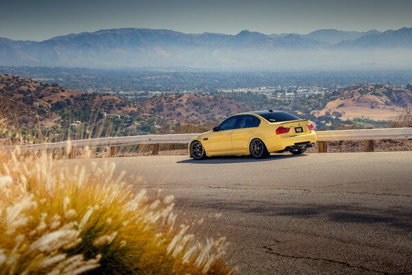 A yellow car is driving on the road