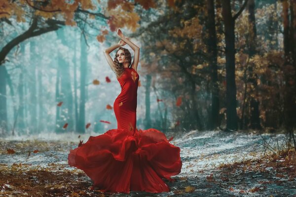 Chica en el bosque de otoño en el fondo de la caída de las hojas