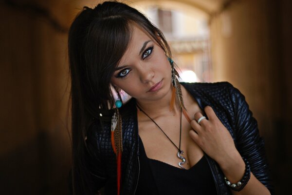 Feather earrings. a beautiful girl. leather jacket. leather jacket