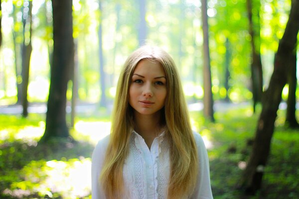 Hermosa chica en el fondo de la naturaleza verde en verano