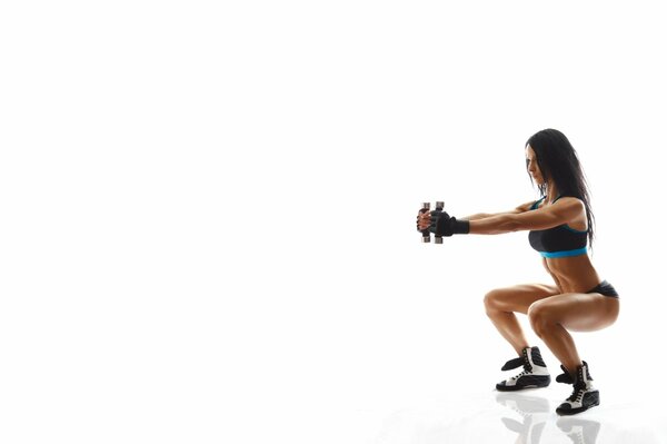 Sexy girl with dumbbells doing exercises