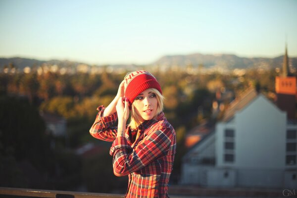 La chica de Caperucita roja en el fondo de la ciudad