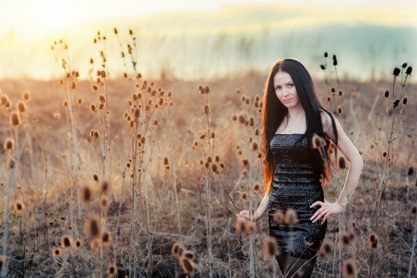 Fille brune en noir dans l herbe