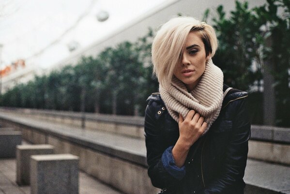 Young blonde in beige scarf and black jacket