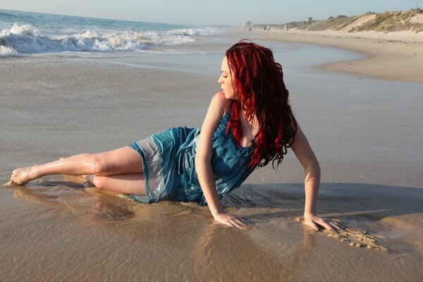 Belle fille aux cheveux rouges sur la plage