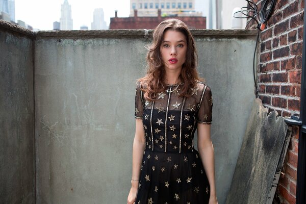 A girl in a black T-shirt with stars on the balcony