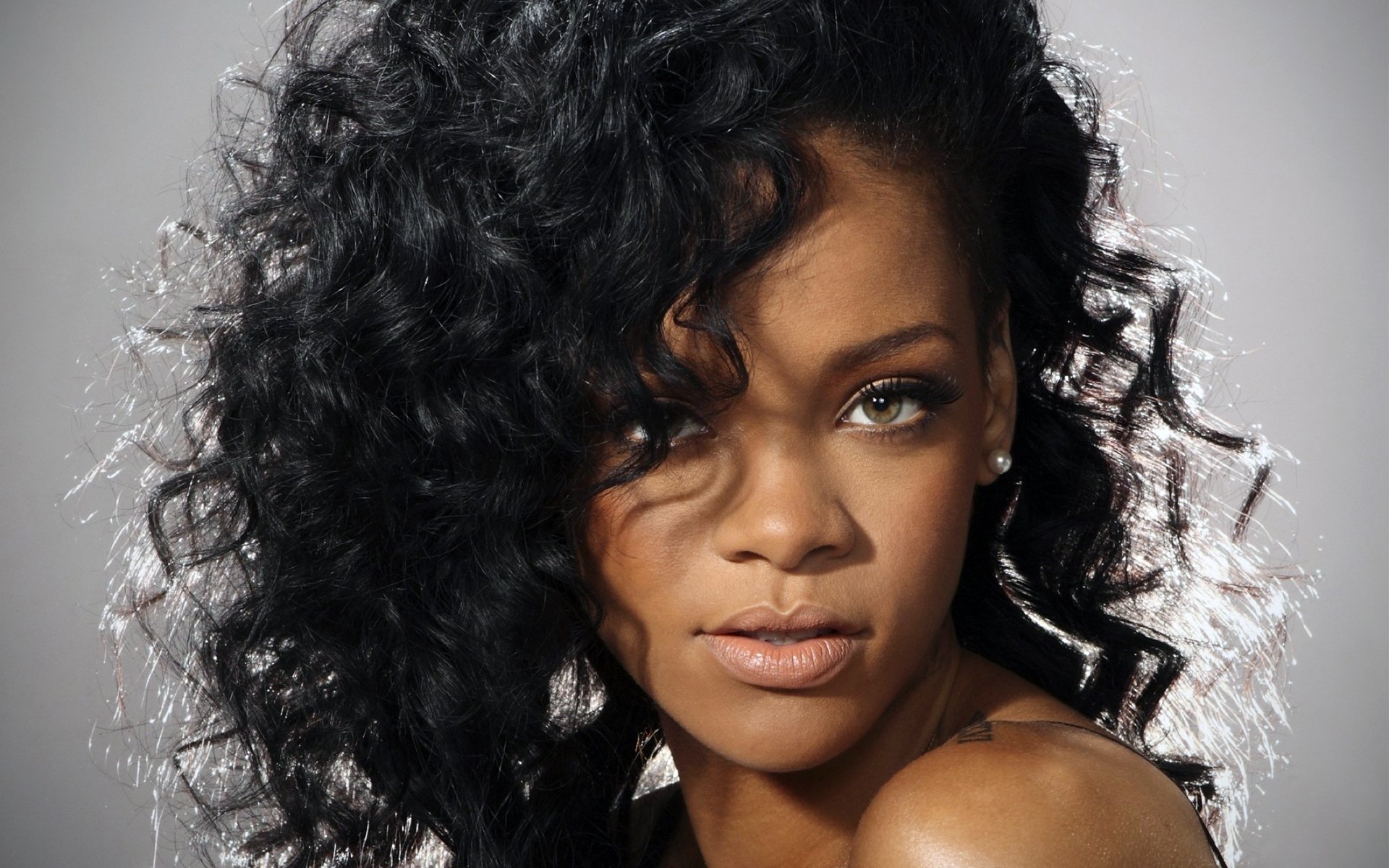 rihanna cantante riccioli capelli occhi sguardo sfondo