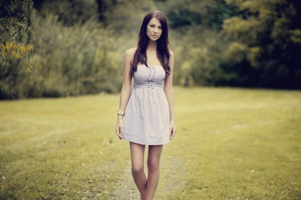 Brunette in a white dress in nature