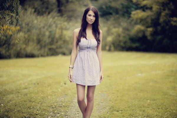 Morena en vestido blanco en la naturaleza