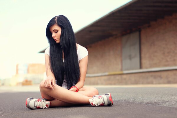 Brunette en position de Lotus sur l asphalte