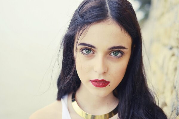 Portrait of a green-eyed girl with a mole, expressive look