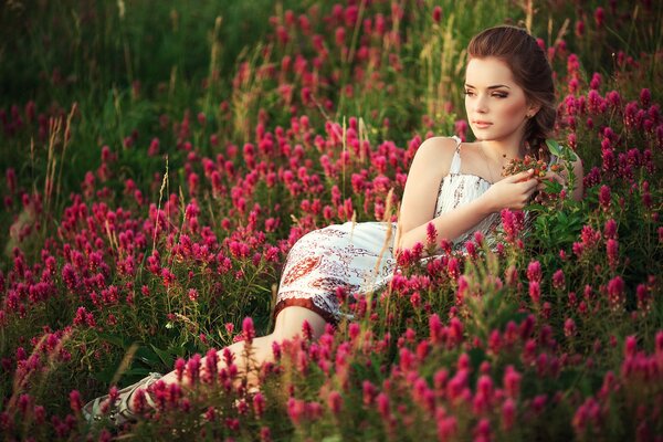Dziewczyna pole na trawie z kwiatami