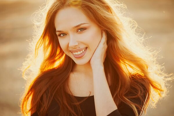 Red-haired girl laughs at the camera