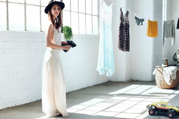 Photo shoot for ELLE magazine. A girl in a hat in a bright room