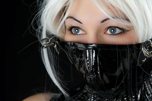 The face of a girl in latex with big eyes