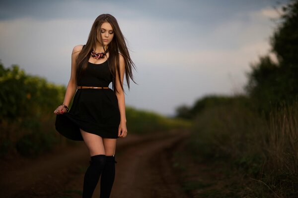 Tina in a black dress and knee socks on the road