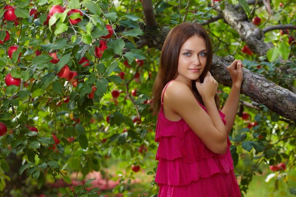 A girl in a pink dress by a tree