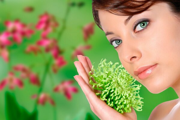 Green-eyed model with a blooming flower