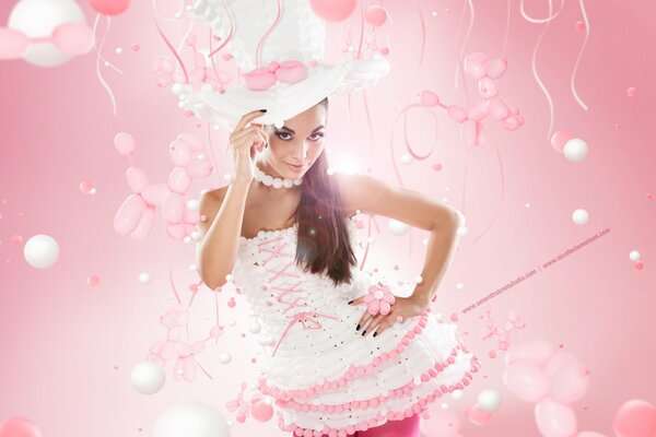 A girl in a hat poses against a background of pink balloons