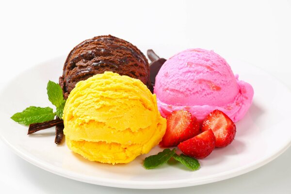 Colorful ice cream balls on a plate with strawberries