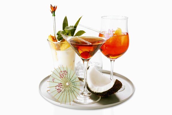 Cocktail in bicchieri con ombrello su un vassoio di cocco